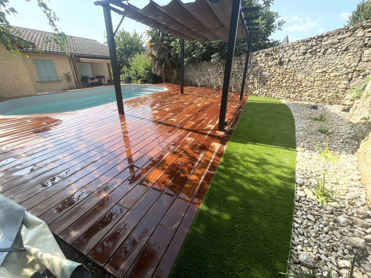 Terrasse en bois exotique autour d'une piscine, démontrant un aménagement extérieur réalisé par un paysagiste professionnel.      4o